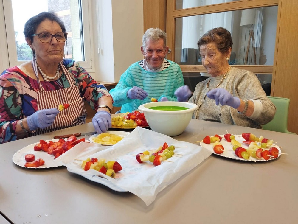 hiru egoiliarrek fruta-brotxetak prestatzen dituzte